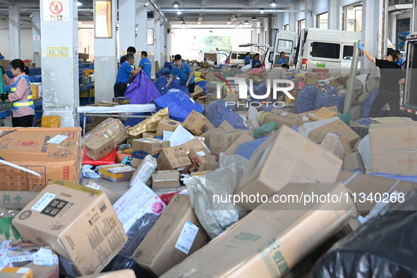 Workers are sorting parcels at an express logistics company in Taicang, China, on June 18, 2024. 