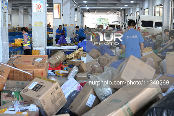 Workers are sorting parcels at an express logistics company in Taicang, China, on June 18, 2024. 