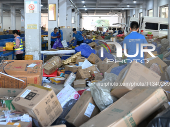 Workers are sorting parcels at an express logistics company in Taicang, China, on June 18, 2024. (