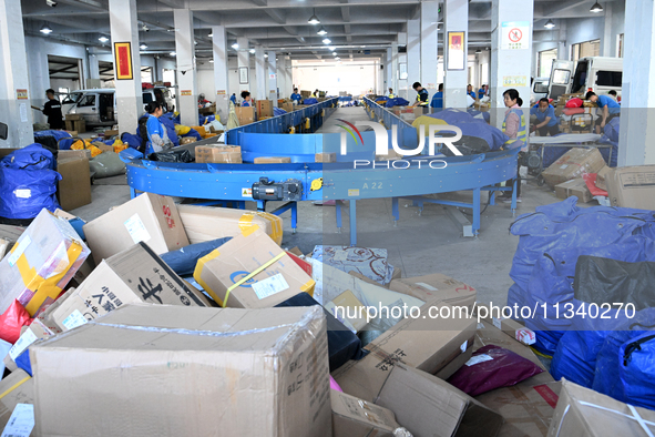 Workers are sorting parcels at an express logistics company in Taicang, China, on June 18, 2024. 