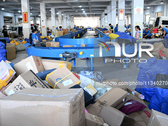 Workers are sorting parcels at an express logistics company in Taicang, China, on June 18, 2024. (