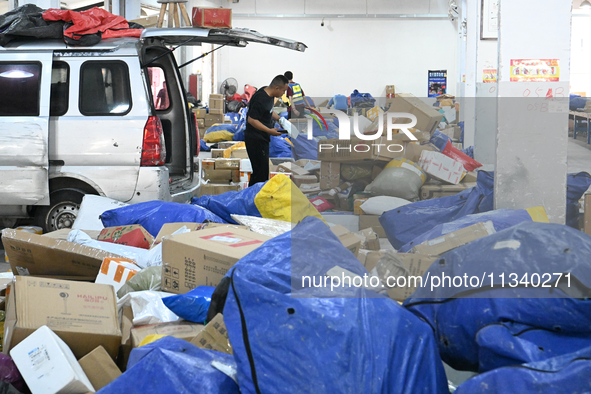 Workers are sorting parcels at an express logistics company in Taicang, China, on June 18, 2024. 