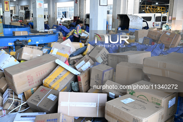 Workers are sorting parcels at an express logistics company in Taicang, China, on June 18, 2024. 