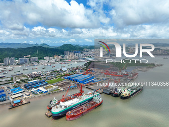 Workers are repairing a ship under the hot sun at the Zhoushan Wanbang Yongyue Ship Repair Co., LTD in Putuo district of Zhoushan City, Zhej...