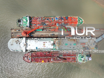 Workers are repairing a ship under the hot sun at the Zhoushan Wanbang Yongyue Ship Repair Co., LTD in Putuo district of Zhoushan City, Zhej...