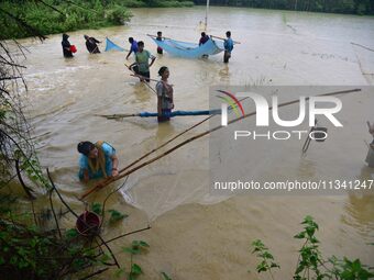 People are fishing on flood water following rains in Changchaki village in Nagaon District of Assam, India, on June 18, 2024. (