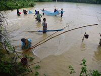 People are fishing on flood water following rains in Changchaki village in Nagaon District of Assam, India, on June 18, 2024. (