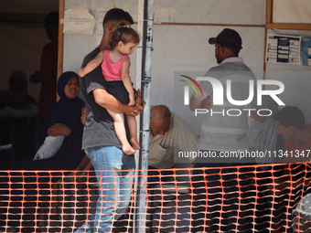 People are waiting inside the UK-Med hospital in southern Gaza, which is being set up to try to meet what it is describing as an ''overwhelm...