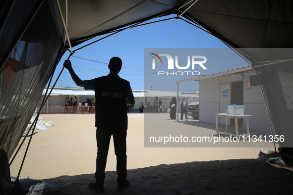 People are waiting inside the UK-Med hospital in southern Gaza, which is being set up to try to meet what it is describing as an ''overwhelm...