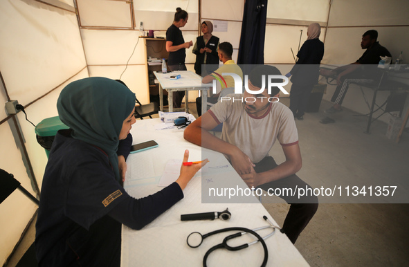 People are waiting inside the UK-Med hospital in southern Gaza, which is being set up to try to meet what it is describing as an ''overwhelm...