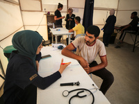 People are waiting inside the UK-Med hospital in southern Gaza, which is being set up to try to meet what it is describing as an ''overwhelm...