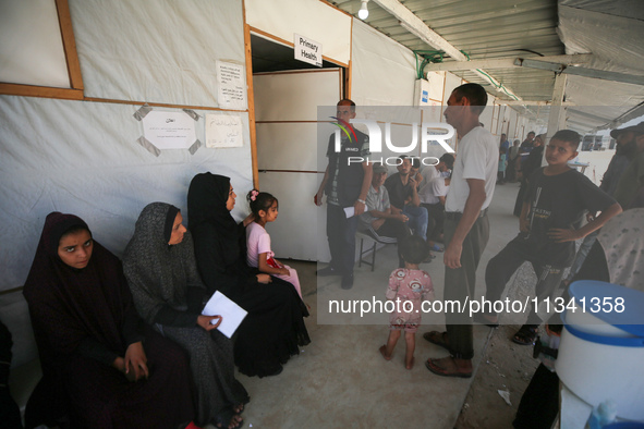 People are waiting inside the UK-Med hospital in southern Gaza, which is being set up to try to meet what it is describing as an ''overwhelm...