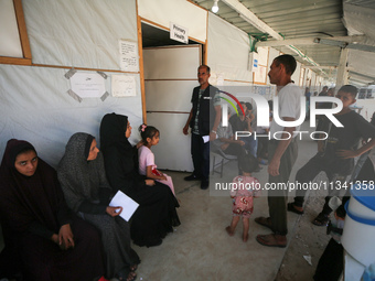 People are waiting inside the UK-Med hospital in southern Gaza, which is being set up to try to meet what it is describing as an ''overwhelm...