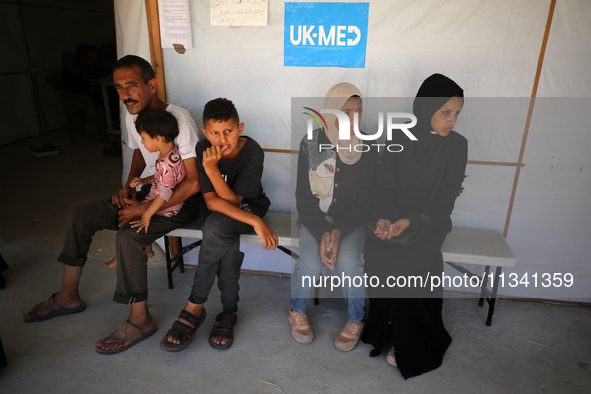 People are waiting inside the UK-Med hospital in southern Gaza, which is being set up to try to meet what it is describing as an ''overwhelm...