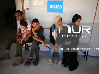 People are waiting inside the UK-Med hospital in southern Gaza, which is being set up to try to meet what it is describing as an ''overwhelm...