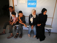 People are waiting inside the UK-Med hospital in southern Gaza, which is being set up to try to meet what it is describing as an ''overwhelm...