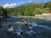 Men are taking a bath in a stream on a sunny day in Kangan, about 70kms from Srinagar, on June 18, 2024. (