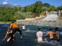 Men are taking a bath in a stream on a sunny day in Kangan, about 70kms from Srinagar, on June 18, 2024. (