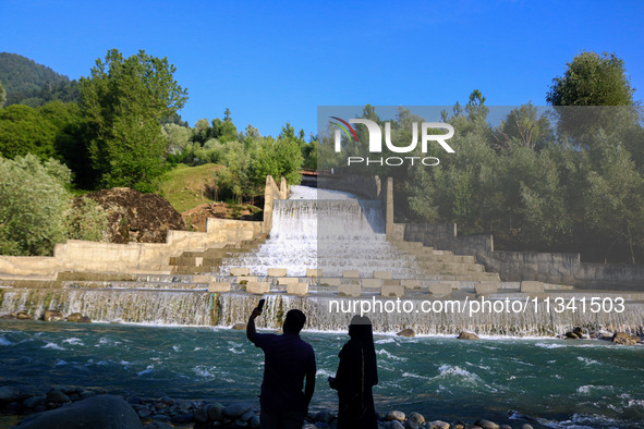 A couple is taking a selfie near the Barwalla waterfall in Kangan, about 70kms from Srinagar, on June 18, 2024. 