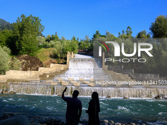 A couple is taking a selfie near the Barwalla waterfall in Kangan, about 70kms from Srinagar, on June 18, 2024. (