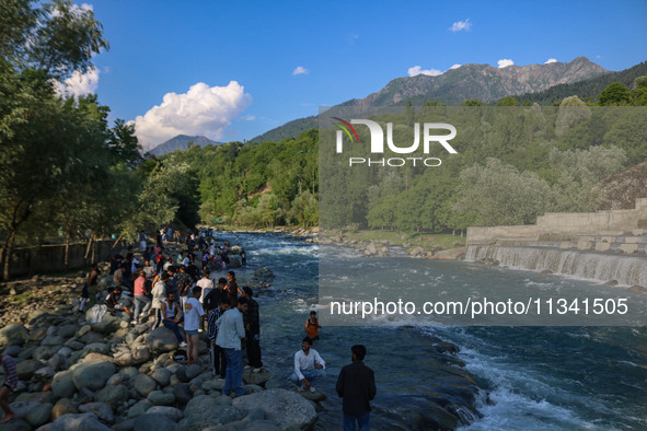 Visitors are touring near the Barwalla waterfall in Kangan, about 70kms from Srinagar, on June 18, 2024. 