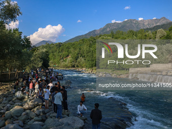 Visitors are touring near the Barwalla waterfall in Kangan, about 70kms from Srinagar, on June 18, 2024. (