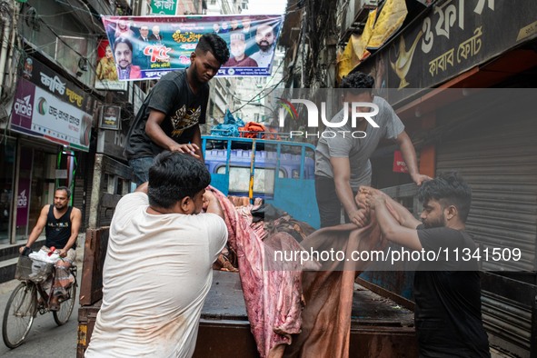 Workers are carrying rawhide from sacrificial cattle to a local factory for preservation by sprinkling salt, a day after Eid-ul-Adha, known...