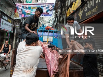 Workers are carrying rawhide from sacrificial cattle to a local factory for preservation by sprinkling salt, a day after Eid-ul-Adha, known...