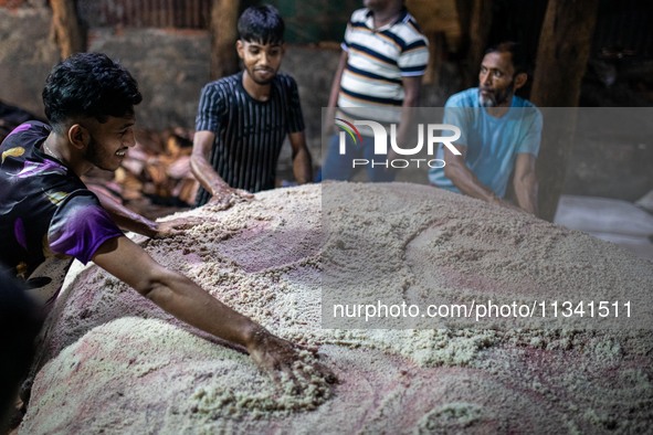 Workers are carrying rawhide from sacrificial cattle to a local factory for preservation by sprinkling salt, a day after Eid-ul-Adha, known...