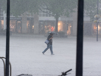 A woman is struggling with her umbrella during the storm in Dortmund, Germany, on June 18, 2024. (