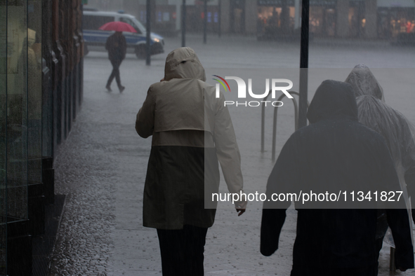 People are struggling to walk during the stormy weather in Dortmund, Germany, on June 18, 2024. 