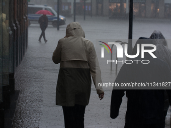 People are struggling to walk during the stormy weather in Dortmund, Germany, on June 18, 2024. (