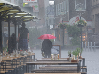 A woman is struggling with her umbrella during the storm in Dortmund, Germany, on June 18, 2024. (