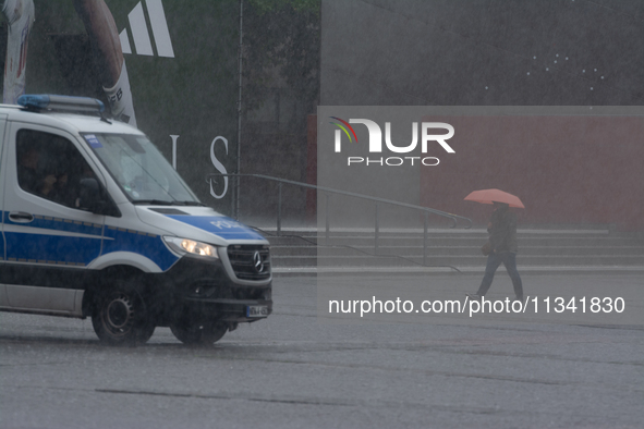 A woman is struggling with her umbrella during the storm in Dortmund, Germany, on June 18, 2024. 