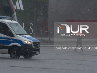 A woman is struggling with her umbrella during the storm in Dortmund, Germany, on June 18, 2024. (