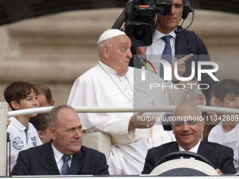 Pope Francis is gesturing as he arrives to lead the weekly general audience in Saint Peter's Square, Vatican City, on June 19, 2024. (