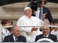 Pope Francis is gesturing as he arrives to lead the weekly general audience in Saint Peter's Square, Vatican City, on June 19, 2024. (