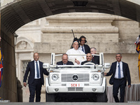 Pope Francis is waving as he is arriving to lead the weekly general audience in Saint Peter's Square, Vatican City, on June 19, 2024. (