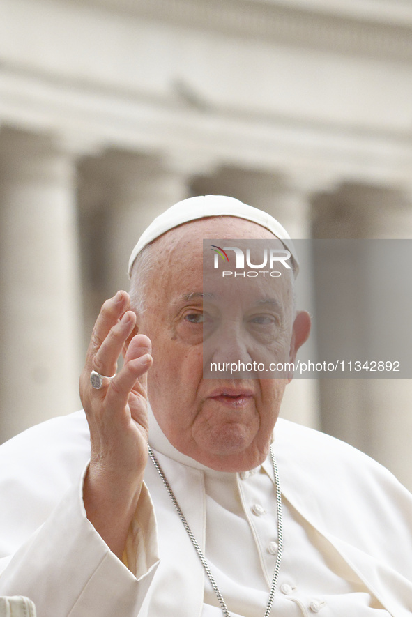 Pope Francis is blessing the crowd as he is arriving to lead the weekly general audience in The Vatican, on June 19, 2024, at St Peter's Squ...