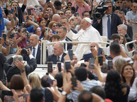 Pope Francis is waving as he is arriving to lead the weekly general audience in Saint Peter's Square, Vatican City, on June 19, 2024. (