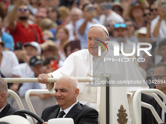 Pope Francis is waving as he is arriving to lead the weekly general audience in Saint Peter's Square, Vatican City, on June 19, 2024. (