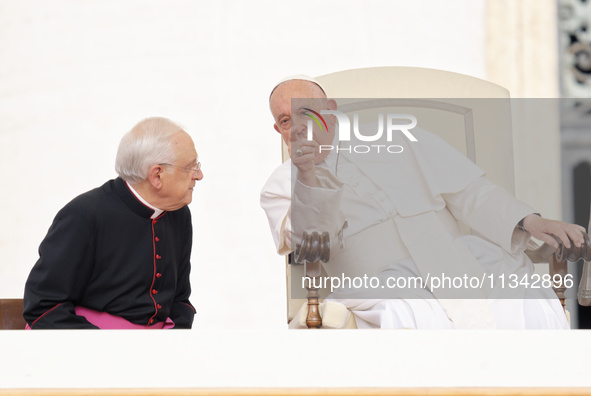 Pope Francis is talking with Monsignor Leonardo Sapienza (L) during his weekly general audience in The Vatican, on June 19, 2024, at St Pete...