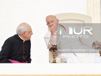 Pope Francis is talking with Monsignor Leonardo Sapienza (L) during his weekly general audience in The Vatican, on June 19, 2024, at St Pete...