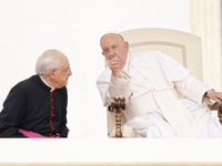 Pope Francis is talking with Monsignor Leonardo Sapienza (L) during his weekly general audience in The Vatican, on June 19, 2024, at St Pete...