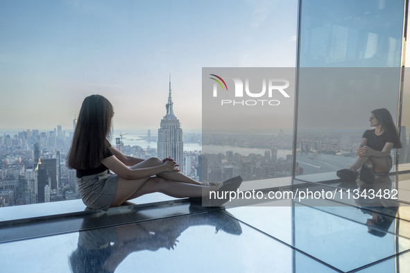 A woman is looking at the Empire State Building from the Summit One Vanderbilt observation deck in New York, U.S., on June 18, 2024. The att...