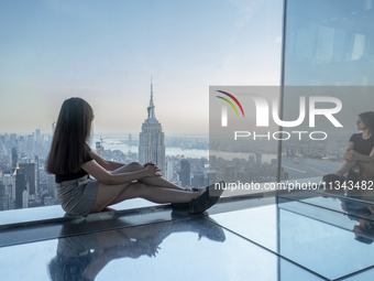 A woman is looking at the Empire State Building from the Summit One Vanderbilt observation deck in New York, U.S., on June 18, 2024. The att...