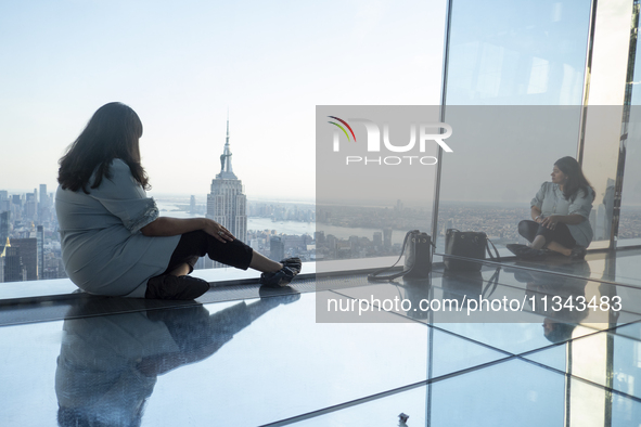 A woman is looking at the Empire State Building from the Summit One Vanderbilt observation deck in New York, U.S., on June 18, 2024. The att...