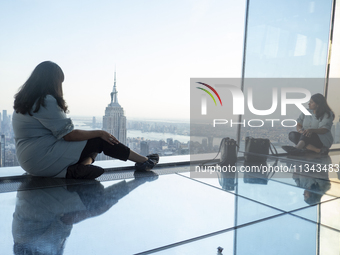 A woman is looking at the Empire State Building from the Summit One Vanderbilt observation deck in New York, U.S., on June 18, 2024. The att...