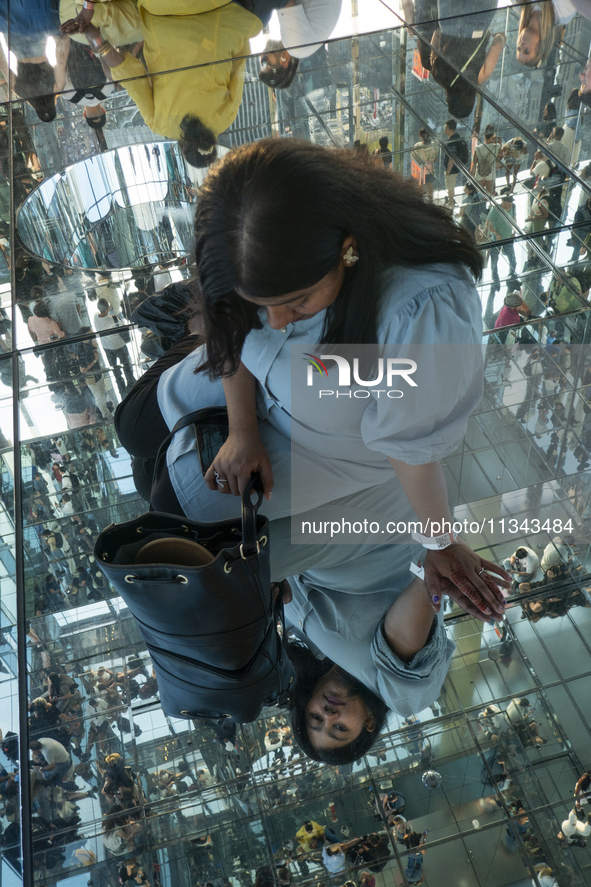 A woman is watching her reflection at the Summit One Vanderbilt observation deck in New York, U.S., on Thursday, June 18, 2024. The Summit O...