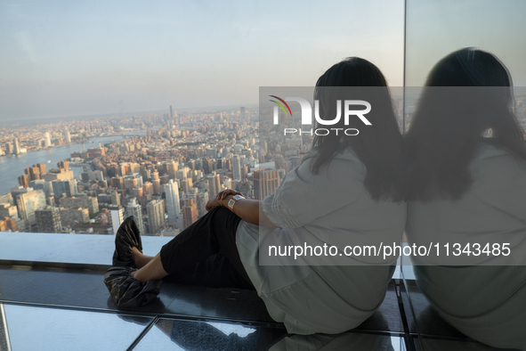 A woman is looking at the top view of New York City from the Summit One Vanderbilt observation deck in New York, U.S., on June 18, 2024. The...